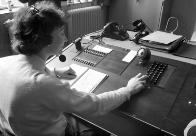 154355 Afbeelding van een telefoniste in de nieuwe telefooncentrale in een van de hoofdgebouwen van N.S. te Utrecht.